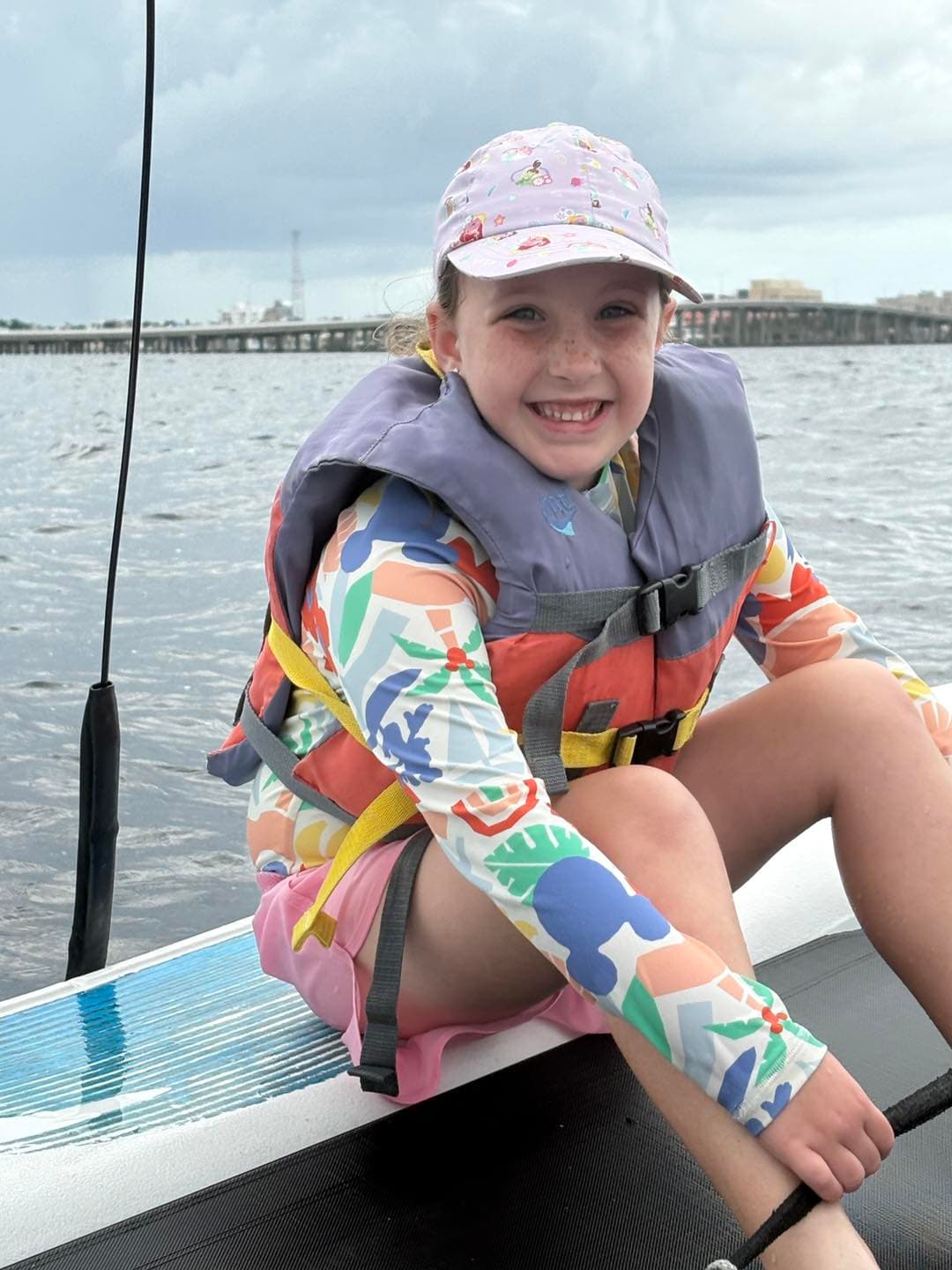 Smiling girl in life jacket on a sailboat