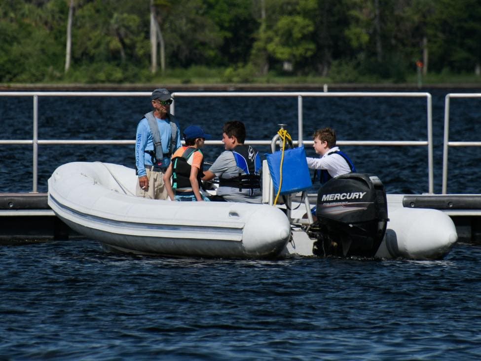 Young girl focused while sailing an Optimist