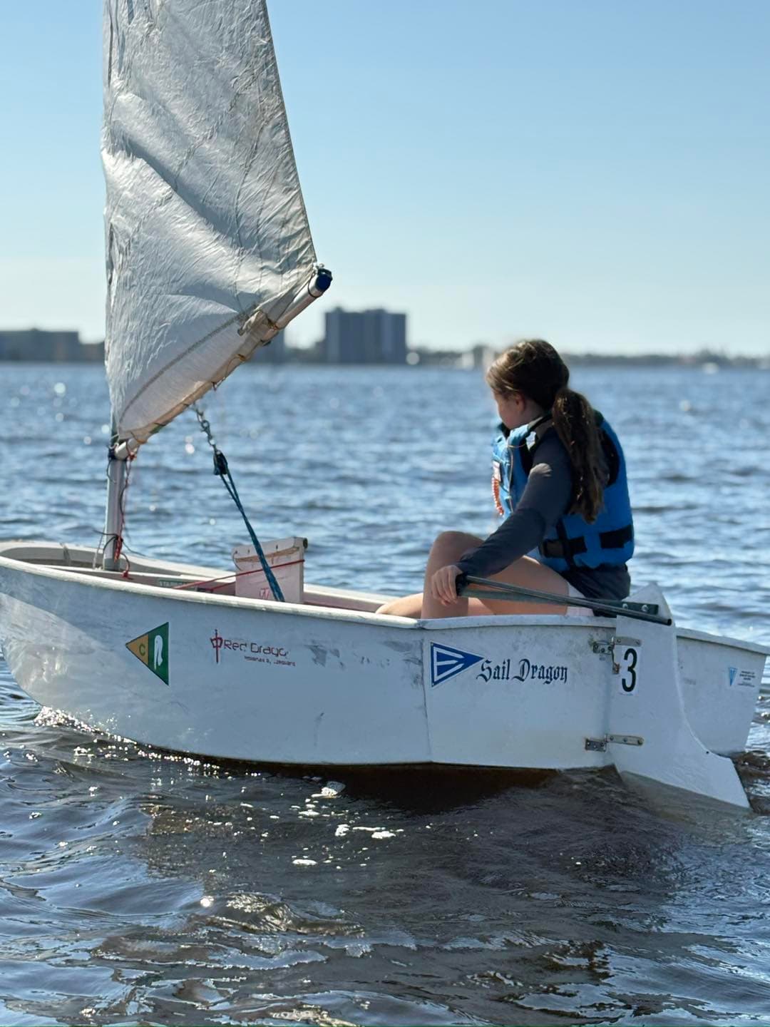 Young girl sailing an Optimist solo
