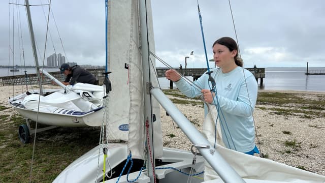 Teen rigging a sailboat up close